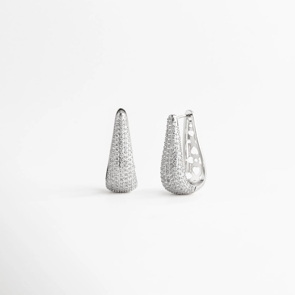 Aretes tipo arracada alargada de cobre con baño de oro blanco 18k y pavé de zirconias, Par de pendientes cónicos elegantes con incrustaciones totales de zirconias sobre fondo blanco, Arracadas de lujo en oro blanco 18k con diseño estilizado de 4 cm de largo, Pendientes modernos con acabado de micro-zirconias brillantes y silueta curvada, Joyería de cobre enchapada en plata/oro blanco con piedras zirconias facetadas.