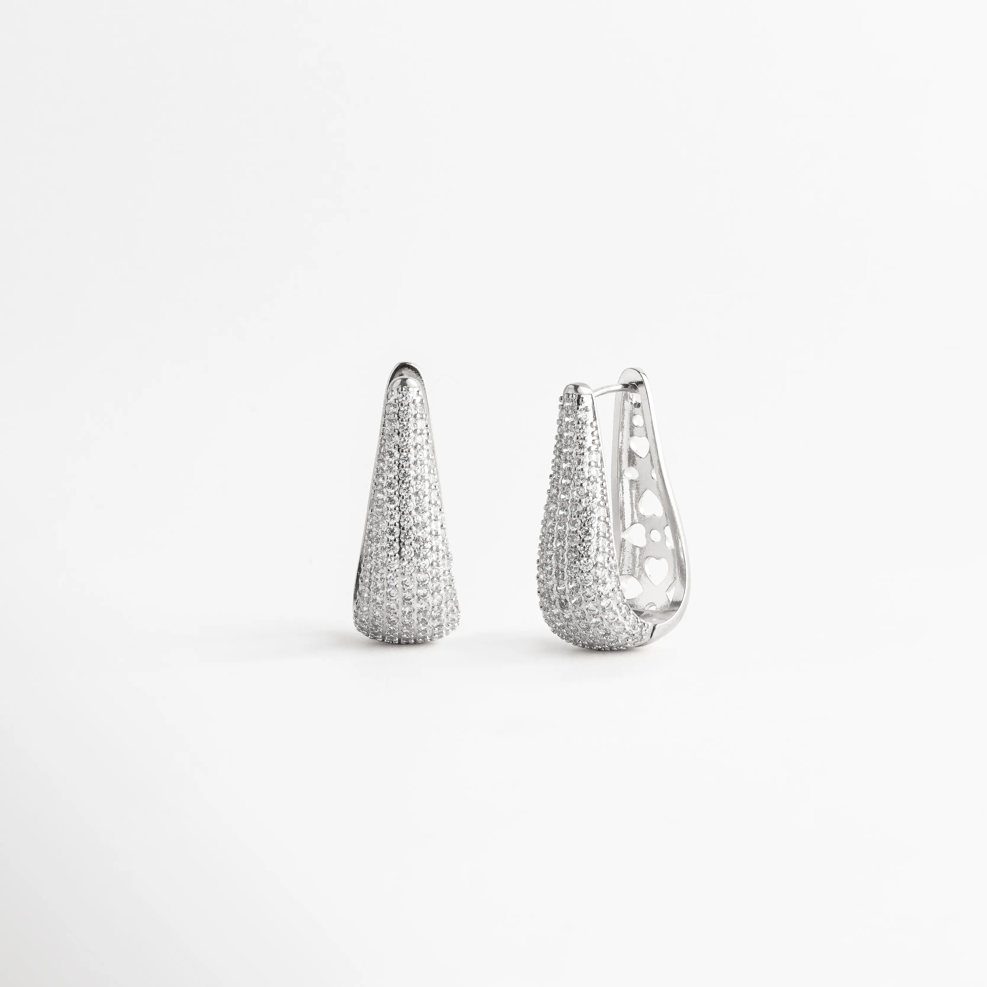 Aretes tipo arracada alargada de cobre con baño de oro blanco 18k y pavé de zirconias, Par de pendientes cónicos elegantes con incrustaciones totales de zirconias sobre fondo blanco, Arracadas de lujo en oro blanco 18k con diseño estilizado de 4 cm de largo, Pendientes modernos con acabado de micro-zirconias brillantes y silueta curvada, Joyería de cobre enchapada en plata/oro blanco con piedras zirconias facetadas.