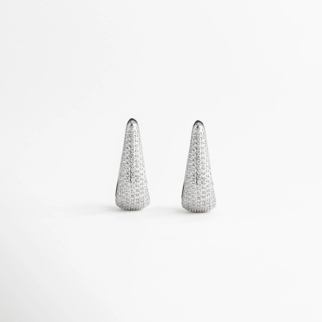 Vista frontal simétrica de aretes alargados con incrustaciones de zirconias brillantes, Par de pendientes de gota modernos en oro blanco 18k para eventos especiales, Arracadas de 4 cm con diseño de punta redondeada y brillo total de zirconias, Joyería contemporánea de cobre enchapado con pedrería fina transparente, Aretes colgantes de silueta orgánica con baño de metal precioso y cristales.