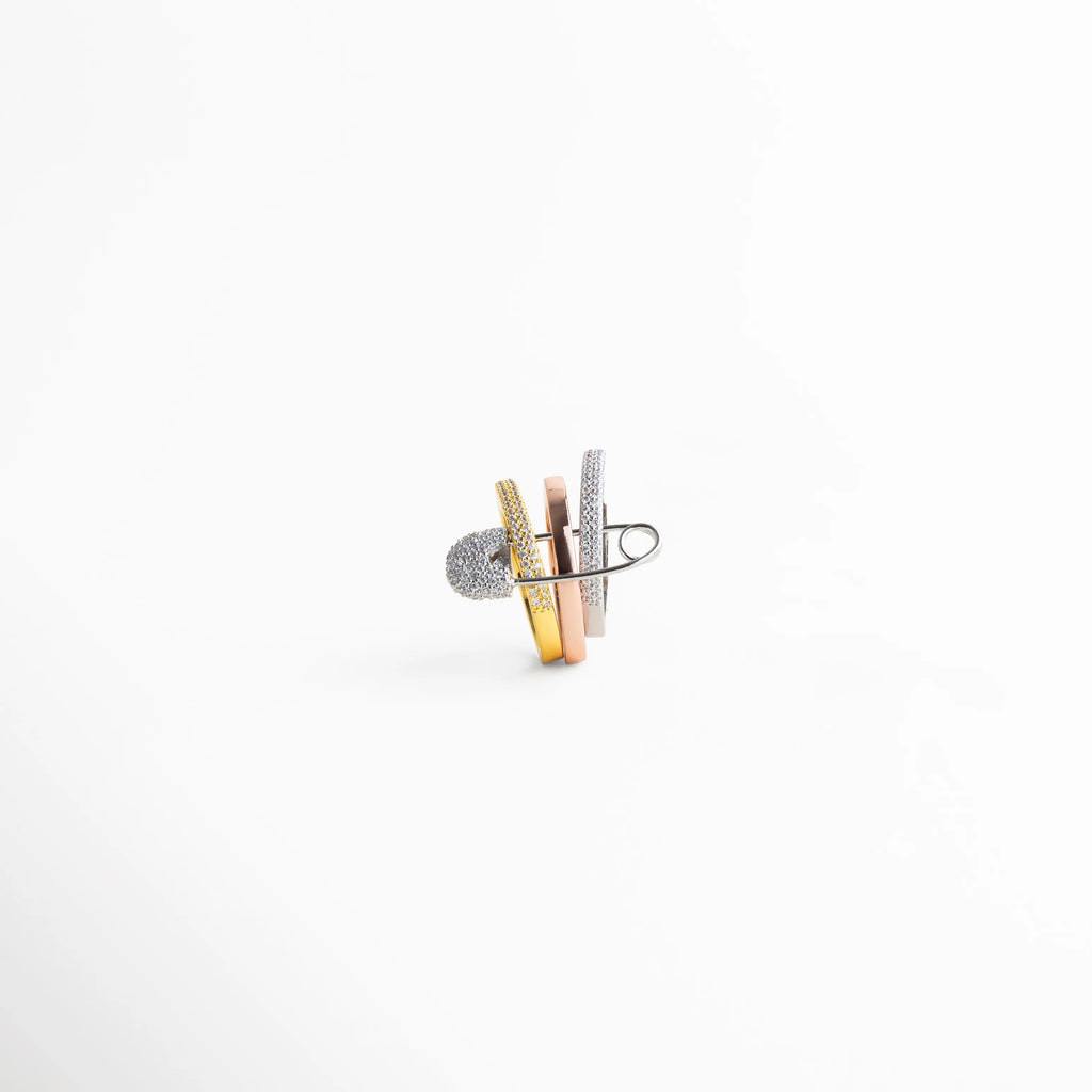 Vista posterior del anillo femenino bicolor con estructura abierta y líneas cruzadas, joyería contemporánea elegante.