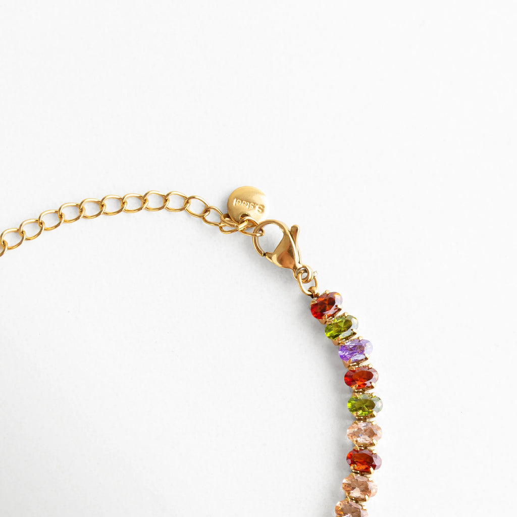 Cierre tipo langosta dorado con cadena ajustable y medalla grabada, resaltando su acabado pulido y cuidado en los detalles.