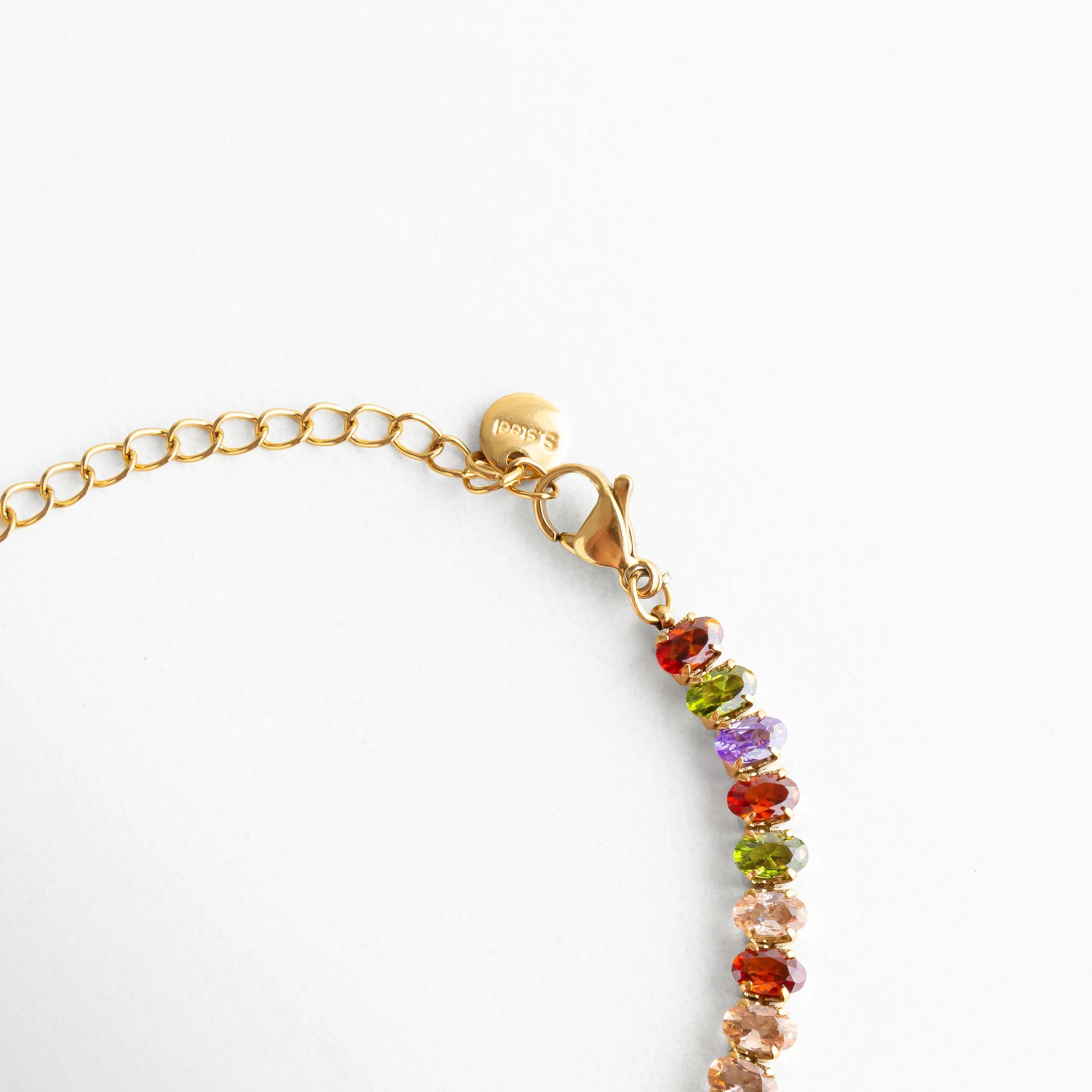 Cierre tipo langosta dorado con cadena ajustable y medalla grabada, resaltando su acabado pulido y cuidado en los detalles.