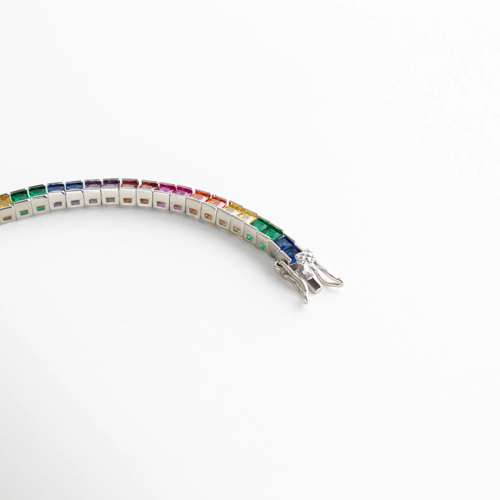Pulsera plateada con cristales en tonos del arcoíris y cierre de seguridad, un diseño vibrante y moderno.