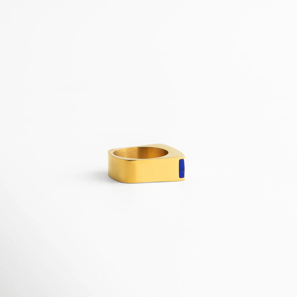Anillo dorado moderno con diseño rectangular y piedra azul, acabado brillante y líneas minimalistas para un estilo elegante y sofisticado.