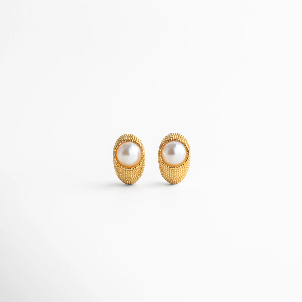 Aretes Bimba dorados con perla sintética, diseño ovalado con textura elegante en acero inoxidable, Par de aretes dorados con incrustación de perla sintética, estilo moderno con acabado texturizado, Aretes ovalados con perla sintética central, chapa de oro 18K y diseño sofisticado, Pendientes dorados con perla sintética y textura tipo joyería imperial, vista frontal, Aretes Bimba con acabado dorado y perla sintética, diseño elegante de 2.5 cm