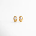 Aretes Bimba dorados con perla sintética, diseño ovalado con textura elegante en acero inoxidable, Par de aretes dorados con incrustación de perla sintética, estilo moderno con acabado texturizado, Aretes ovalados con perla sintética central, chapa de oro 18K y diseño sofisticado, Pendientes dorados con perla sintética y textura tipo joyería imperial, vista frontal, Aretes Bimba con acabado dorado y perla sintética, diseño elegante de 2.5 cm