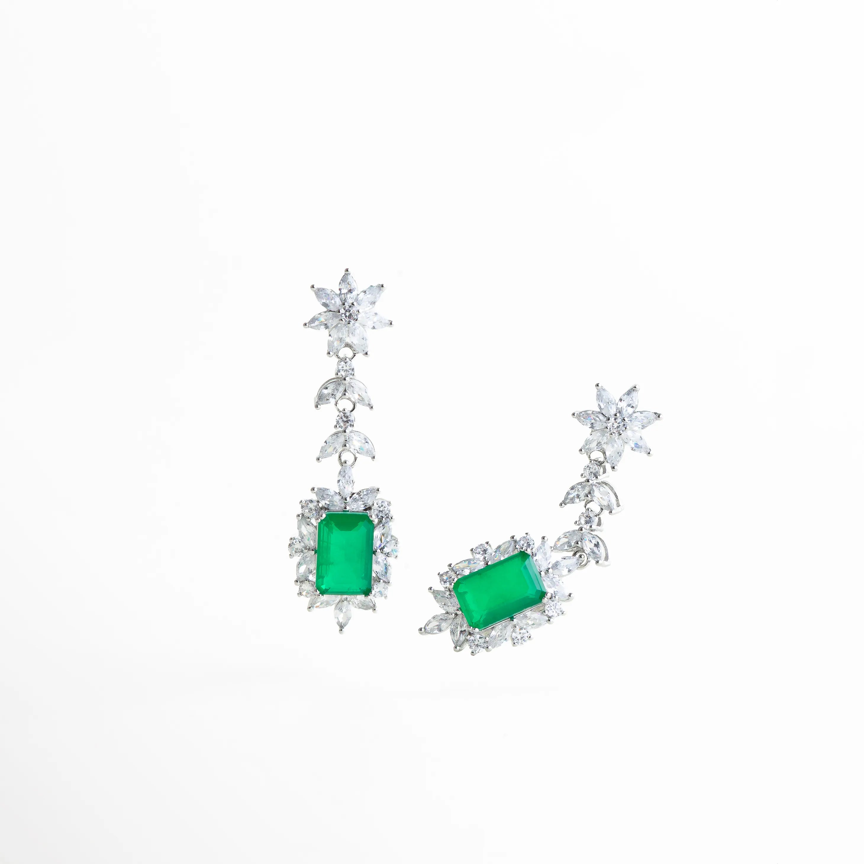 aretes largos plateados puestos en oreja, aretes elegantes para eventos especiales, joyería plateada llamativa pero delicada, aretes con piedra verde para look de noche, aretes colgantes elegantes para mujer
