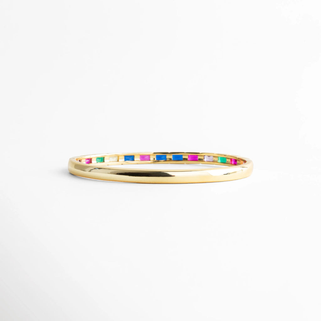 Vista lateral de pulsera delgada con zirconias multicolor, Perfil fino de pulsera dorada con piedras brillantes, Pulsera vista de lado con diseño minimalista y colorido, Detalle lateral de pulsera con incrustaciones multicolor, Pulsera fina dorada con línea continua de zirconias
