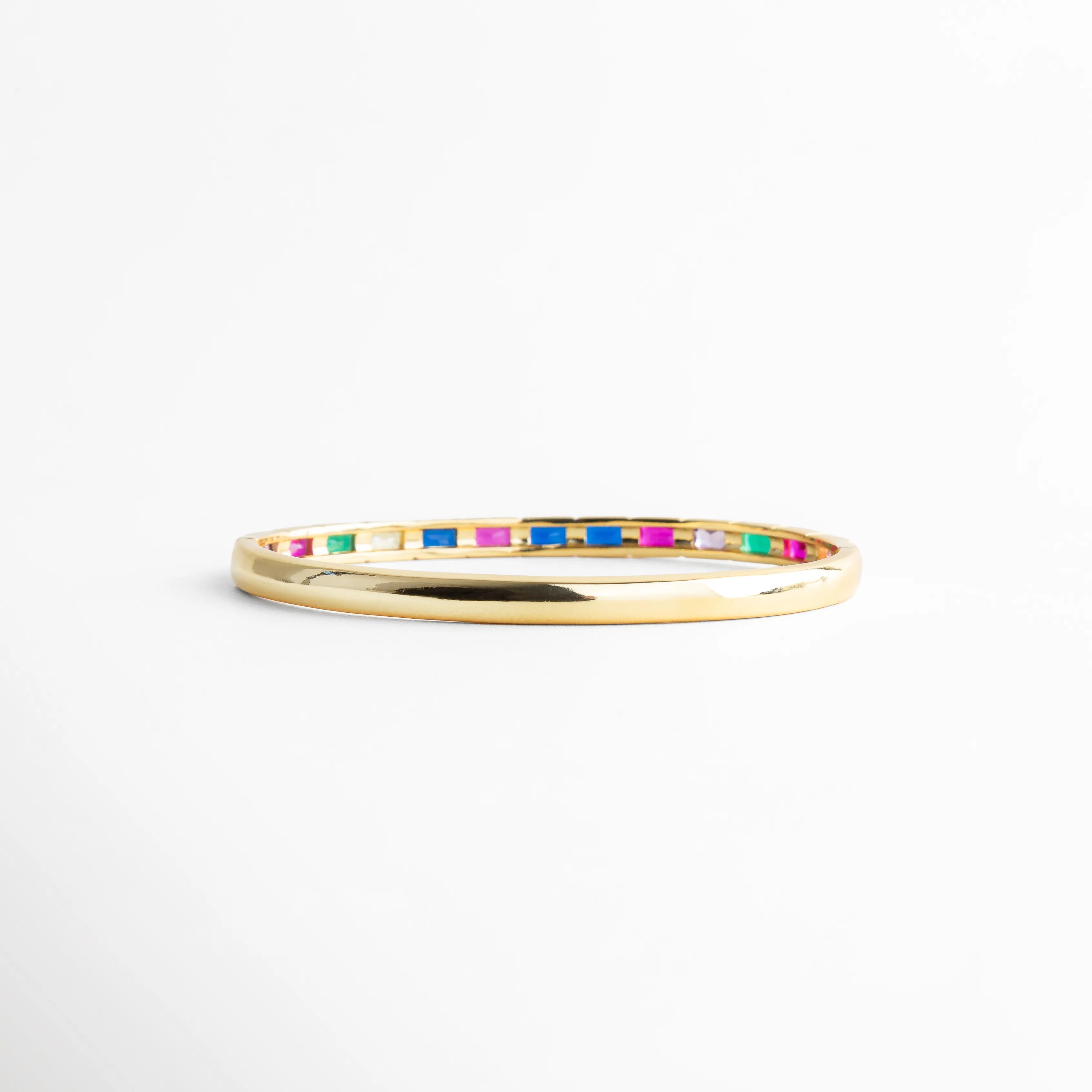 Vista lateral de pulsera delgada con zirconias multicolor, Perfil fino de pulsera dorada con piedras brillantes, Pulsera vista de lado con diseño minimalista y colorido, Detalle lateral de pulsera con incrustaciones multicolor, Pulsera fina dorada con línea continua de zirconias