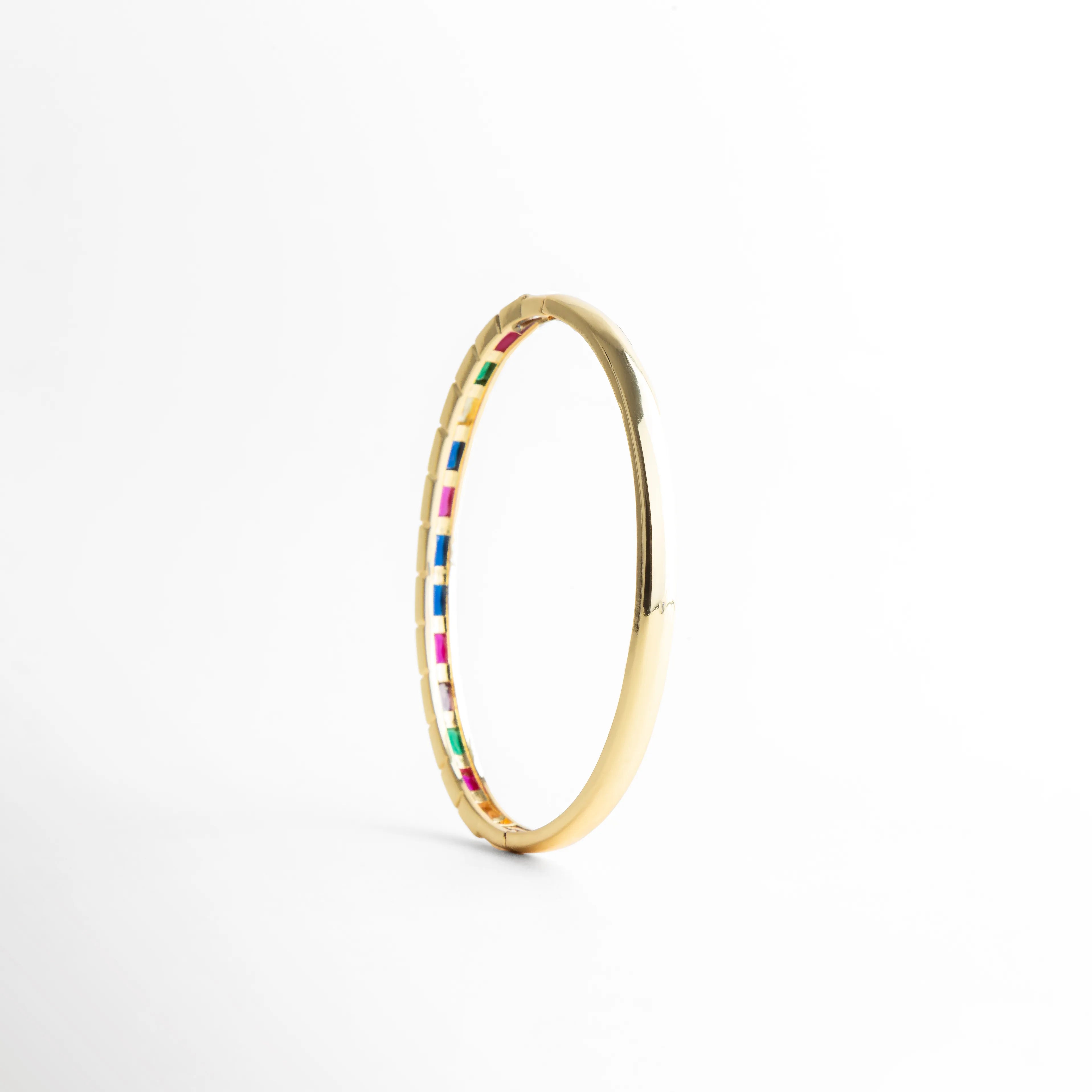 Pulsera dorada vertical con zirconias multicolor brillantes, Vista lateral vertical de pulsera con diseño elegante y colorido, Pulsera en ángulo mostrando piedras multicolor y acabado dorado, Detalle vertical de pulsera con zirconias brillantes, Pulsera Jolie con enfoque lateral y diseño vibrante