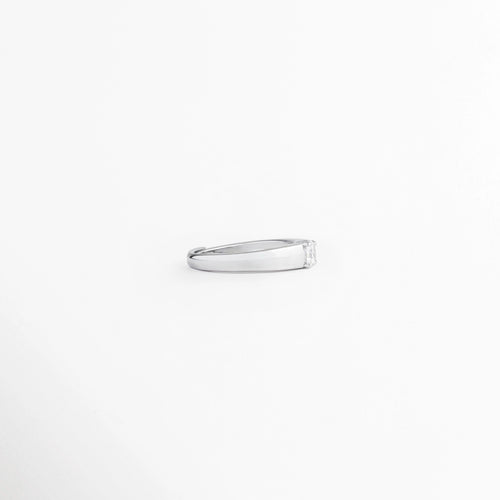 Vista de perfil de anillo ajustable enchapado en oro blanco, mostrando la silueta lisa y delgada de la banda, Perspectiva lateral de anillo minimalista plateado de 0.5 cm sobre fondo blanco limpio, Ángulo de perfil mostrando el pulido impecable y el grosor uniforme del aro del anillo, Detalle lateral de la banda metálica en tono oro blanco sin costuras visibles en la parte superior.