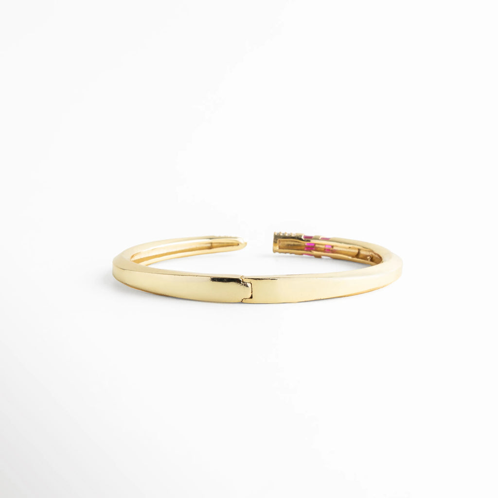Vista posterior del brazalete dorado mostrando el sistema de bisagra para fácil apertura, Detalle técnico del mecanismo de cierre y apertura del brazalete rígido de oro 18K, Pulsera dorada lisa por la parte posterior con acabado espejo y alta calidad de enchapado, Estructura de brazalete con bisagra central, garantizando comodidad y ajuste seguro, Parte trasera de pulsera de lujo con recubrimiento de oro 18K y diseño minimalista.