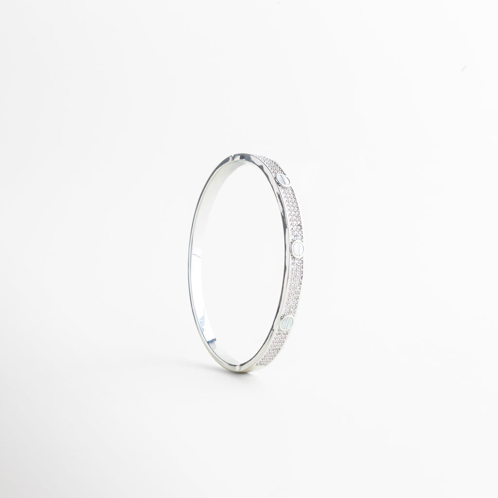 detalle de pulsera con círculos grabados, textura de pulsera metálica con diseño sutil, pulsera con detalles geométricos en primer plano, acabado pulido en pulsera minimal, detalle de joyería femenina moderna