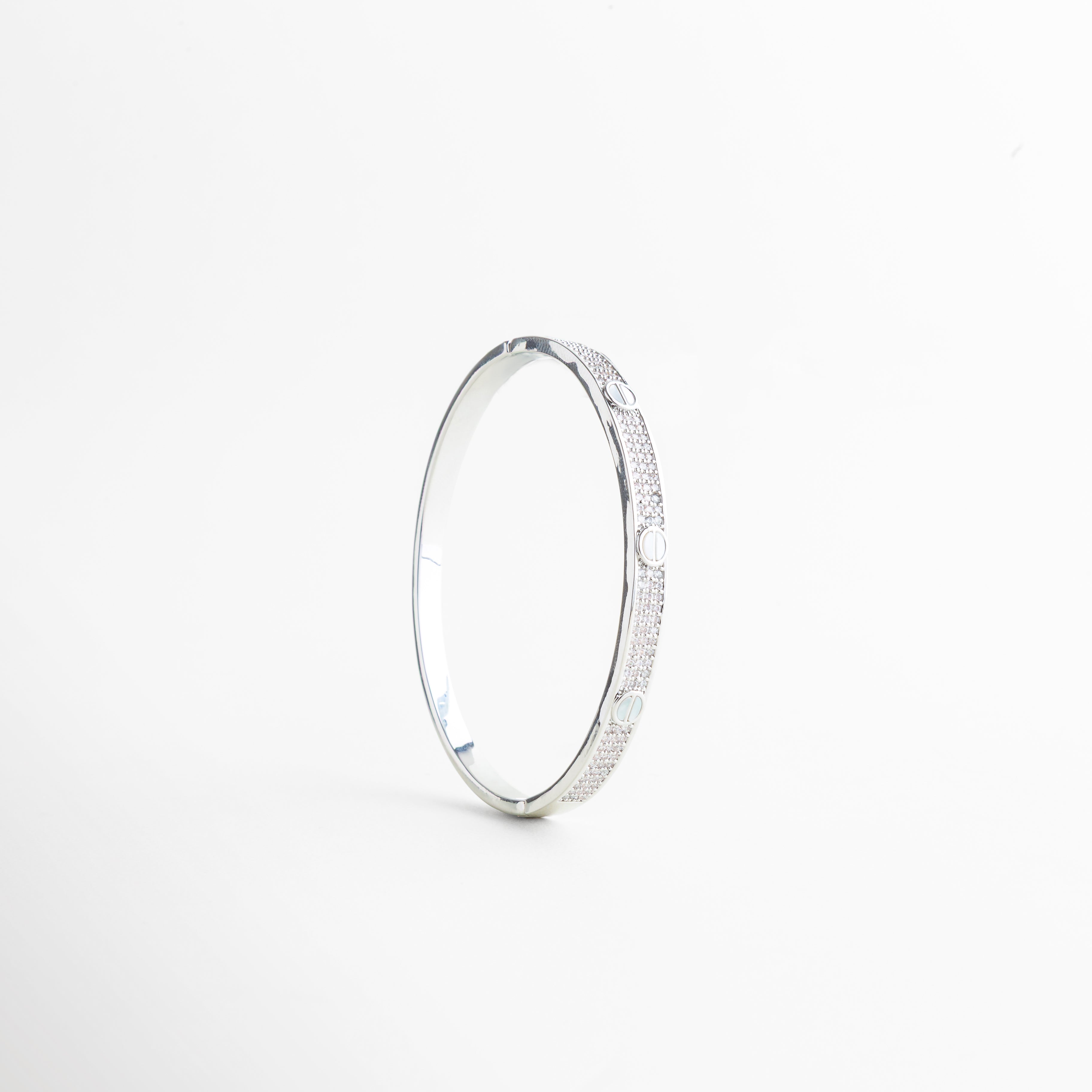 detalle de pulsera con círculos grabados, textura de pulsera metálica con diseño sutil, pulsera con detalles geométricos en primer plano, acabado pulido en pulsera minimal, detalle de joyería femenina moderna