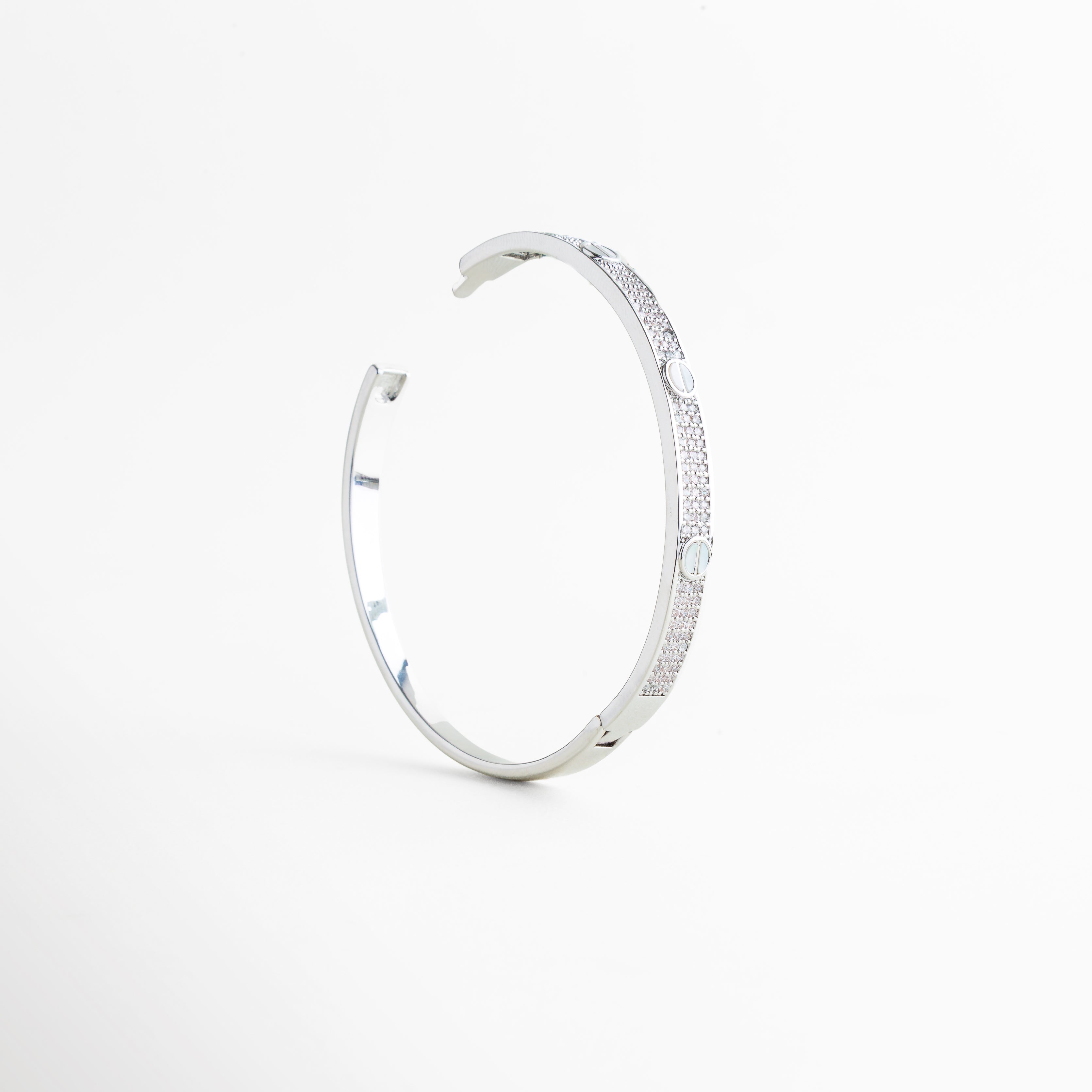 grabado circular en pulsera delgada, diseño minimal con detalles repetidos en pulsera, pulsera metálica con patrón geométrico, textura fina de pulsera elegante, pulsera moderna con detalles discretos