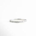 pulsera delgada plateada con detalles circulares grabados, pulsera minimalista de metal con acabado pulido, pulsera femenina estilo moderno vista frontal, joyería minimal pulsera rígida con diseño geométrico, pulsera elegante delgada para uso diario