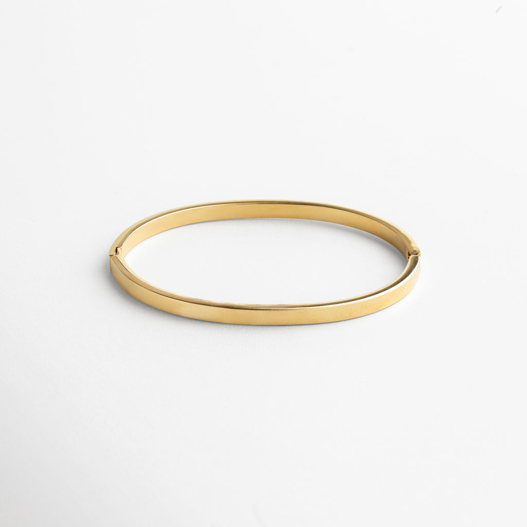 ángulo mostrando la continuidad del brazalete, incrustaciones alineadas en perfecta simetría, estilo clásico reinterpretado con modernidad, detalle que enmarca la muñeca con sofisticación, joya que transmite equilibrio y lujo discreto