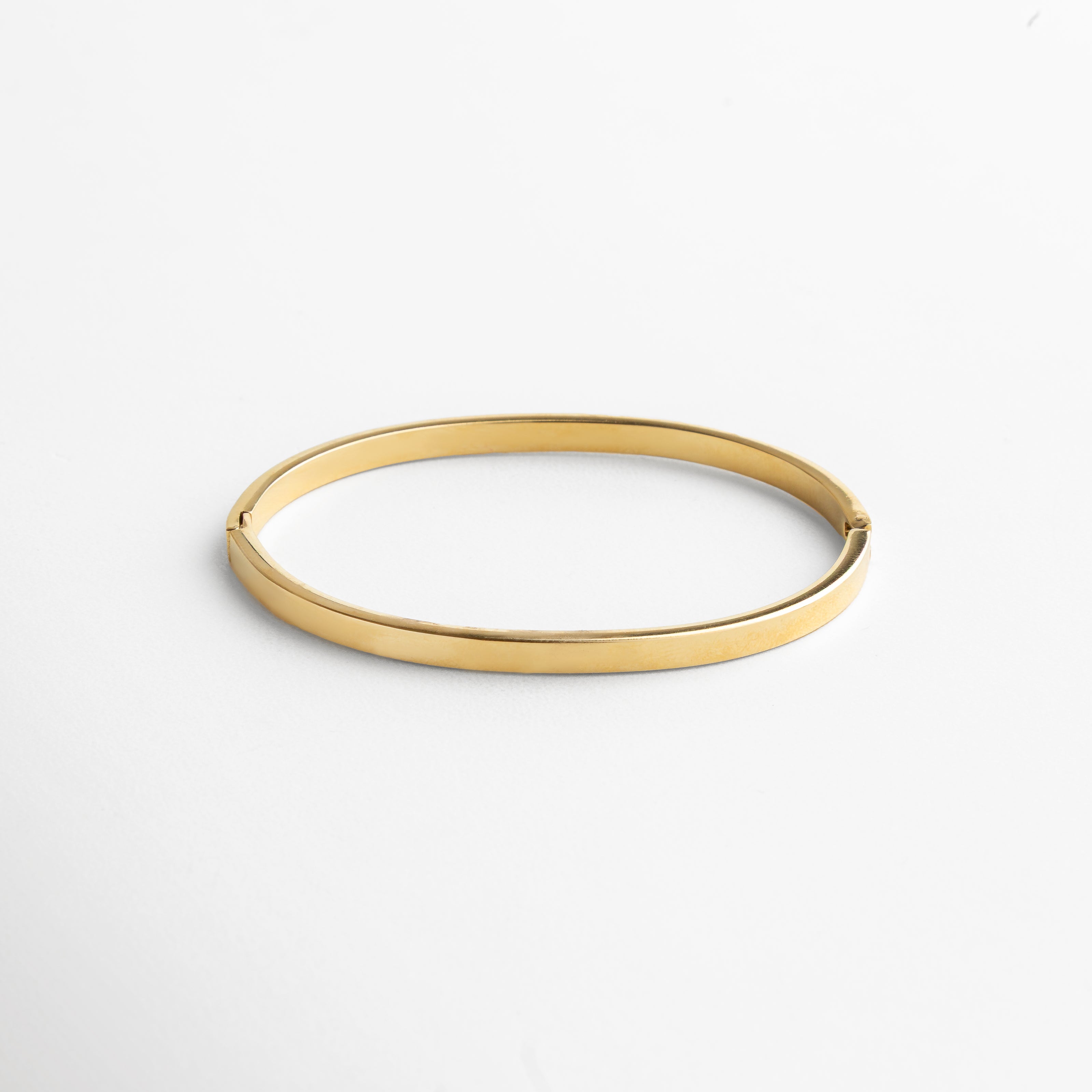 ángulo mostrando la continuidad del brazalete, incrustaciones alineadas en perfecta simetría, estilo clásico reinterpretado con modernidad, detalle que enmarca la muñeca con sofisticación, joya que transmite equilibrio y lujo discreto