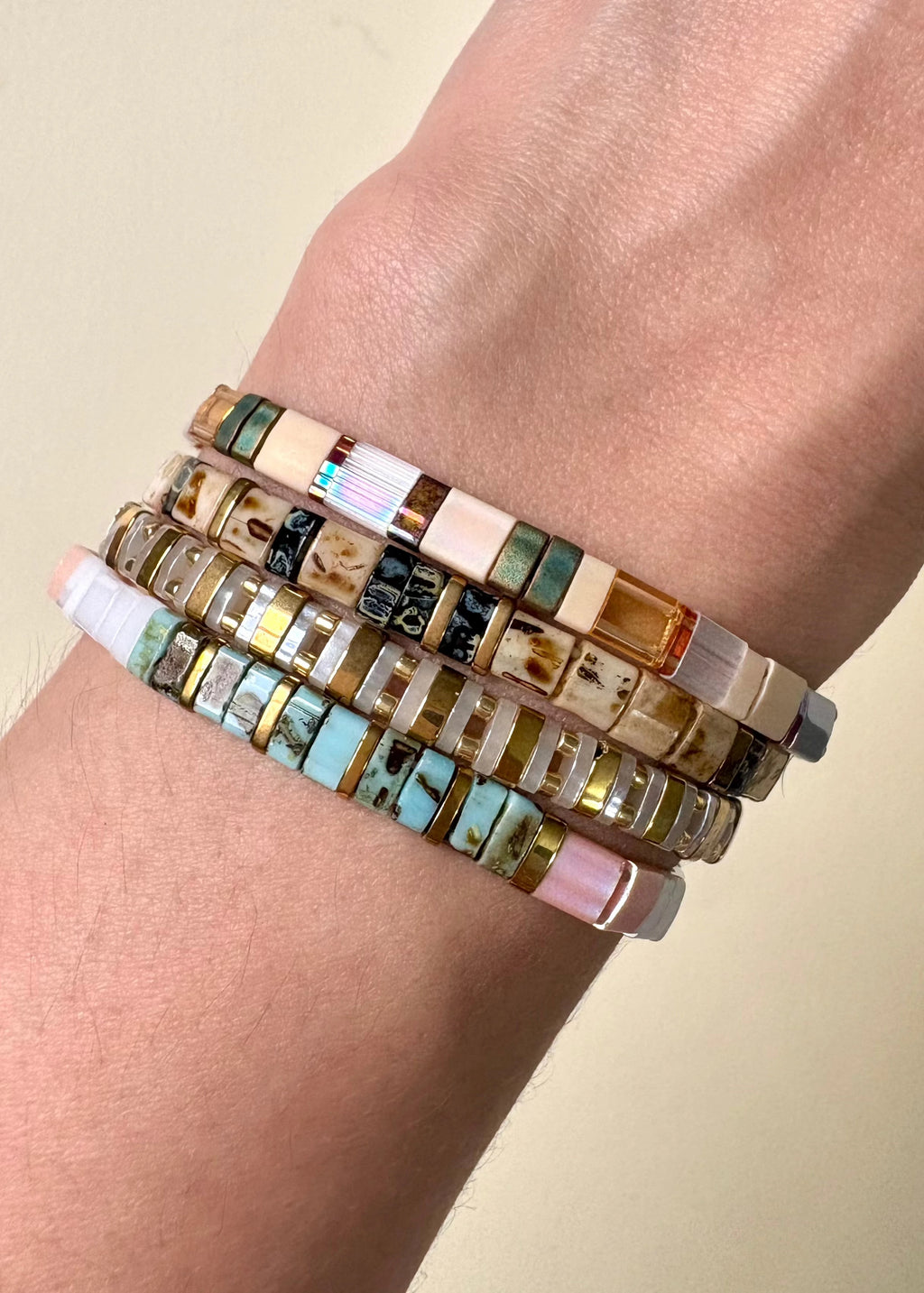 Pulseras rectangulares multicolor estilo mosaico, diseño moderno y artesanal, Pulseras elásticas con cuentas rectangulares en tonos tierra, rosa, dorado y turquesa, Set de pulseras multicolor con rectángulos brillantes, accesorio boho chic versátil.