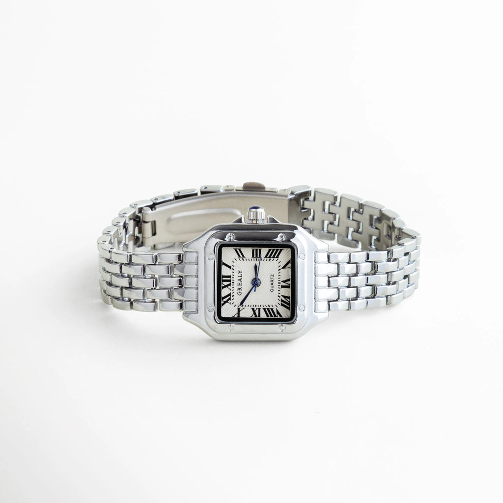 Reloj de mujer en vista diagonal con acabado en oro blanco y diseño sofisticado, Perspectiva del reloj femenino con carátula cuadrada y brazalete metálico elegante, Reloj elegante en acero inoxidable mostrado en ángulo para destacar su diseño refinado, Vista diagonal de reloj para mujer con estilo delicado y acabado brillante, Reloj femenino moderno con diseño versátil y elegante en tono oro blanco.