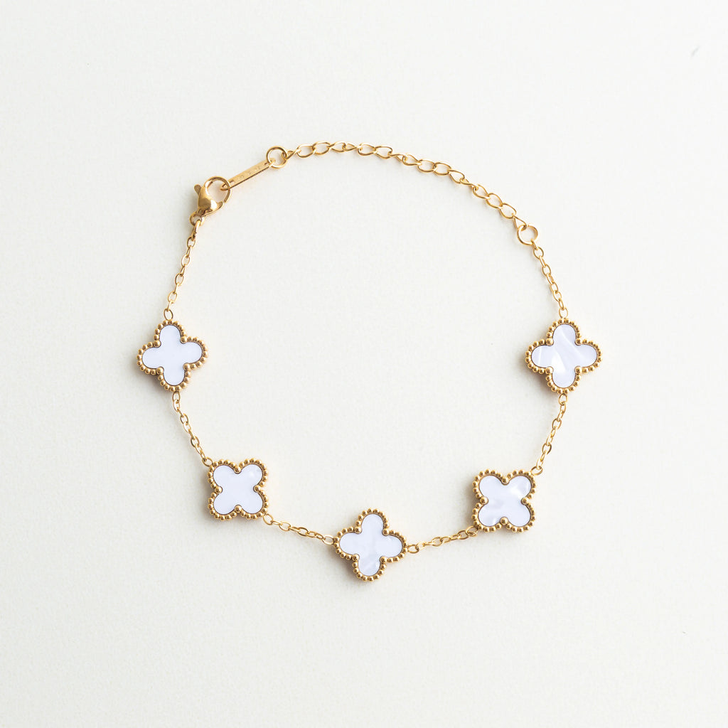 Pulsera dorada con dijes de trébol blanco y acabado elegante, Pulsera de acero inoxidable con tréboles de nácar y baño en oro 18K, Pulsera femenina con dijes de trébol blanco y diseño delicado, Pulsera elegante con detalles de trébol y piedras de nácar, Pulsera completa con tréboles blancos y estilo sofisticado