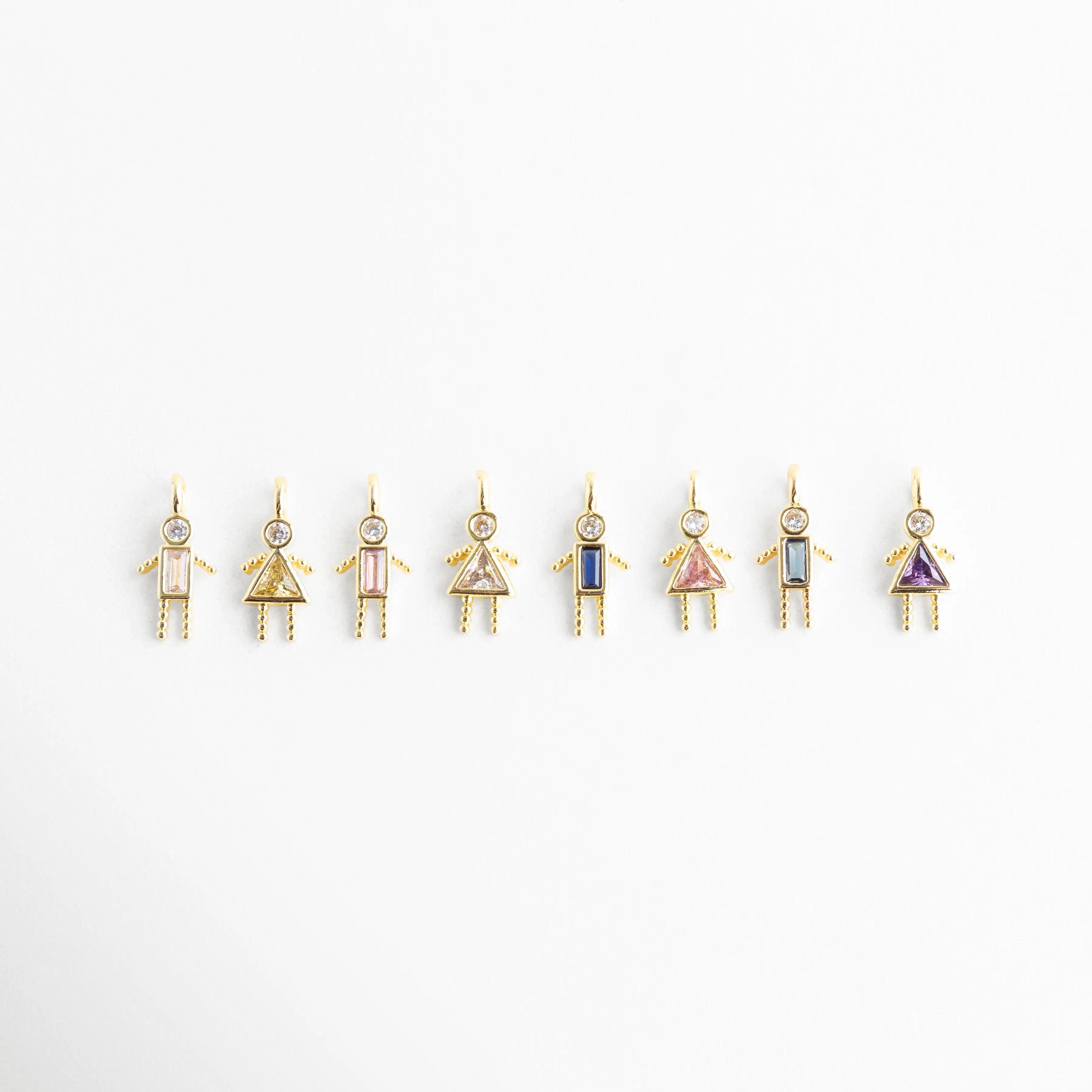 Collares con dije de niño en diferentes colores de zirconia, Variación de colgantes con zirconias de colores en diseño infantil elegante, Collares dorados con dijes pequeños de niño y piedras de colores, Colección de collares con figura de niño y zirconias multicolor, Opciones de collar con dije de niño y zirconias en distintos tonos