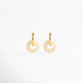 Aretes Emilia Hoops de acero inoxidable con baño de oro 18K y dije circular de ágata natural, Arracadas doradas minimalistas con piedra natural en forma de dona color crema sobre fondo blanco, Joyería de acero inoxidable: aretes tipo hoop con piedra natural orgánica y acabado brillante, Detalle de pendientes Emilia con herraje dorado liso y dije circular de piedra natural veteada, Pendientes contemporáneos con baño de oro de 18 quilates y detalles de ágata blanca.