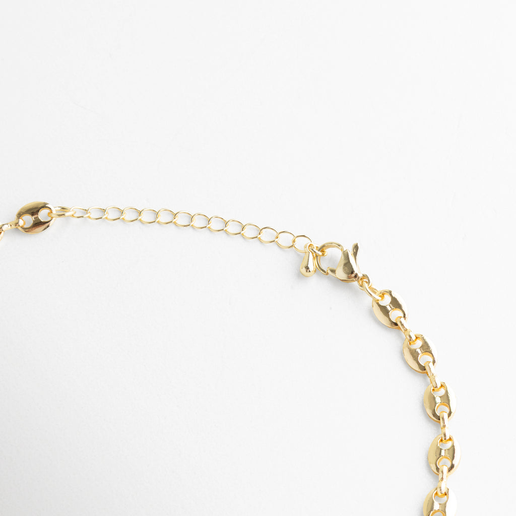 Detalle del broche de langosta y cadena de extensión del collar Liriana, Cierre ajustable de collar enchapado en oro 18K para diferentes medidas de cuello, Vista del sistema de seguridad y eslabones finales del collar dorado Liriana, Acabado del cierre en aleación de cobre con baño de oro premium y pulido, Detalle técnico: cadena ajustable con terminales de alta resistencia y brillo.