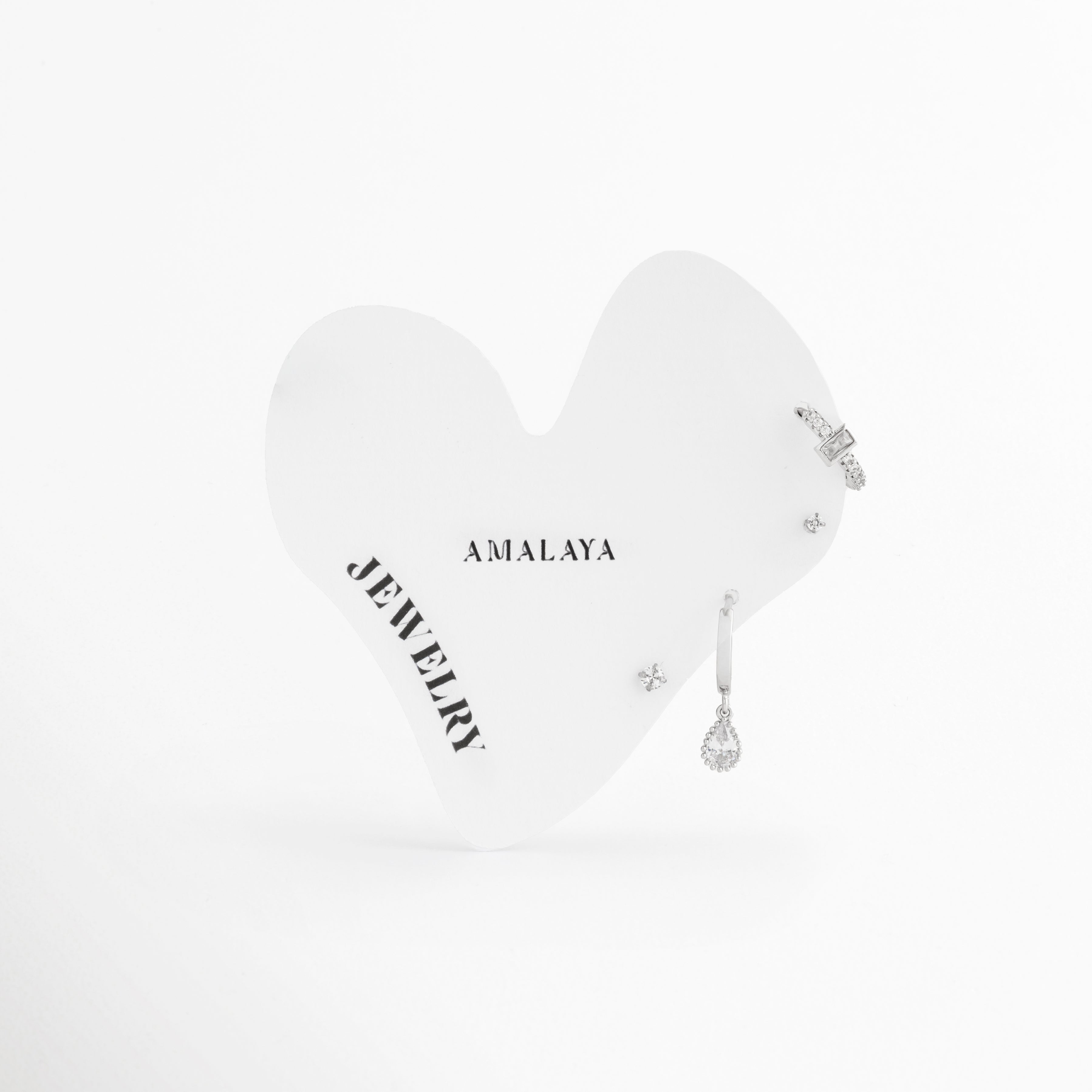 Set de cuatro aretes plateados de acero inoxidable con dije de gota, corte baguette y broqueles solitarios, Cuarteto de aretes pequeños chapados en oro blanco con zirconias de Amalaya Jewelry sobre tarjeta blanca, Joyería de acero inoxidable: mini arracada con piedra rectangular y arete con gota brillante colgante, Aretes para múltiples perforaciones color plata y resistentes al agua sobre fondo blanco, Detalle de combinación elegante para lóbulo y hélix con pedrería fina en oro blanco.